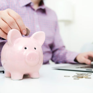 people placing coins into piggy bank to represent employer superannuation contributions and super guarantee rate and the superannuation cap