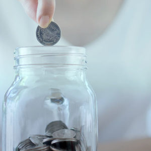 Lady adding coin to savings