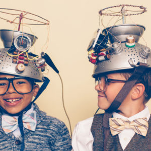 Two Boys Dressed as Nerds Smiling with Mind Reading Helmets, representing innovation