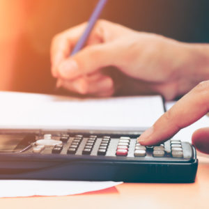 Close up young woman with calculator - salary sacrifice concept