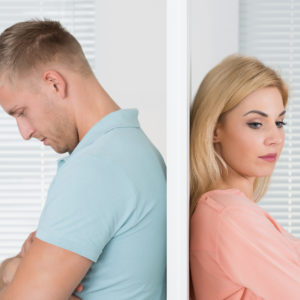Unhappy Couple Standing Back To Back At Home - representing relationship breakdown - splitting super concept