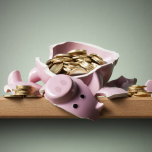 Broken piggy bank with coins. Concept for not receiving superannuation