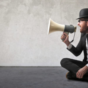 Vintage looking man shouting with a megaphone - representing telling people about his new business