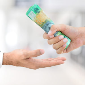 Man hands passing money, Australian dollar (AUD) banknotes - accessing superannuation savings concept