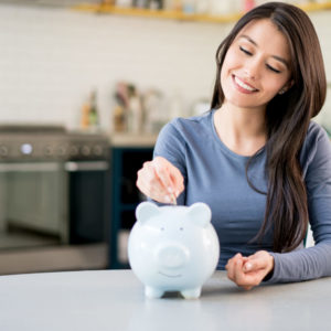 Woman saving money in a piggybank - representing making extra contributions to her superannuation