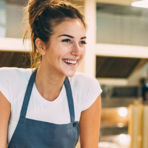 Smiling young baker at the checkout counter.