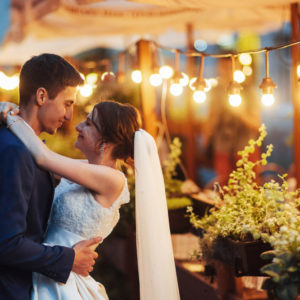 wedding couple at night with lighting and cafe in background