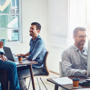 Employees working and chatting in an open plan office - representing how to pay super to staff