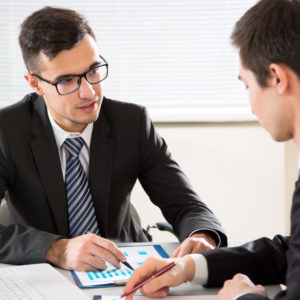 Young business manager discussing superannuation with employee at modern office