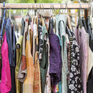 Clothes on a rack on a flea market. Representing how to save money.
