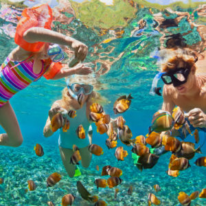 Underwater photo. Happy family snorkelling in tropical sea on holiday