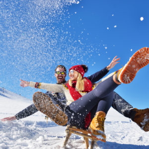 Overseas holiday planner - romantic snow scene with couple on holiday having fun in fresh snow