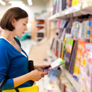 Woman reading a magazine in Newsagency. Newsagency Marketing Tips for Newsagents concept